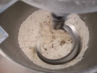 椰蓉吐司,将除黄油以外的所有材料放入搅拌缸里，低速档搅拌至无干粉成团