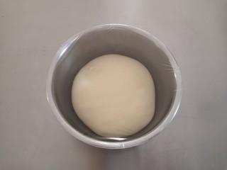 椰蓉吐司,取出面团整理后，放入容器里盖上保鲜膜发酵（基础发酵在26—28度温度环境下发酵）