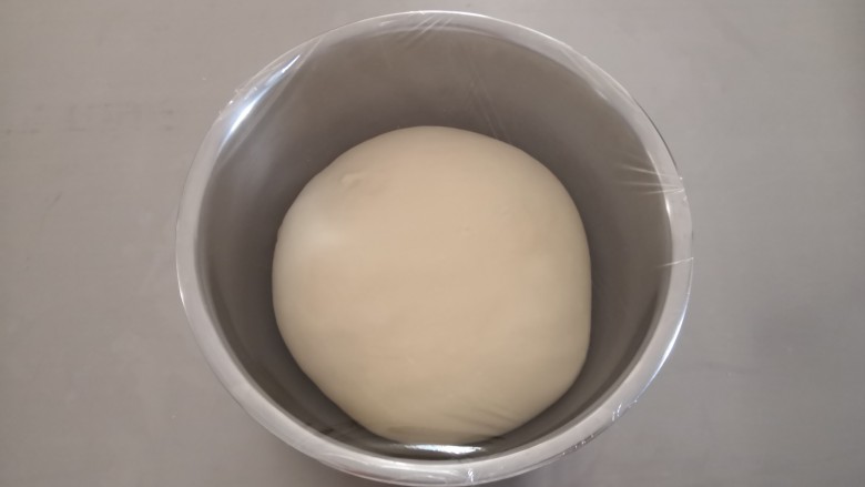 椰蓉吐司,取出面团整理后，放入容器里盖上保鲜膜发酵（基础发酵在26—28度温度环境下发酵）