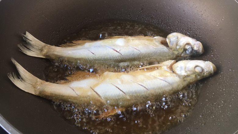 红烧鲢鱼,将鲢鱼的两面都蘸上薄薄的一层面粉，抖去多余的面粉，锅烧热后放入油（量大些），当油温5～6成热时放入鲢鱼。