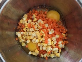 火腿鸡蛋饼,鸡蛋打入容器里，加入玉米粒和胡萝卜粒。