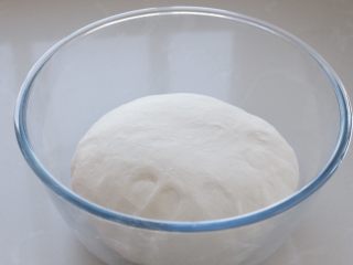 东北猪肉酸菜馅饺子,在面粉中加入温水，用筷子搅拌成棉絮状，再用手揉成光滑的面团，覆盖保鲜膜静置一旁饧面约30分钟