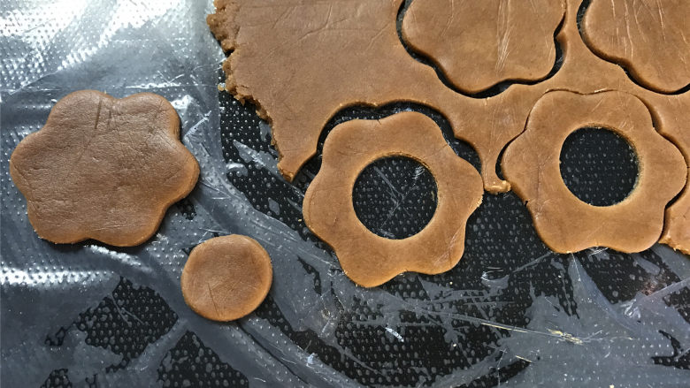 咖啡果酱小饼,再用一个小的圆形模具在面片中间抠出圆心。这个两个形状的面片数量要一致。