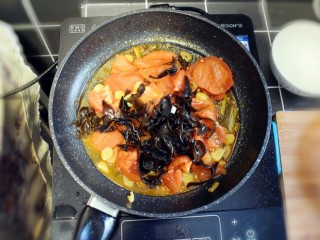 番茄炒包菜盖浇饭,西红柿变软，汤汁炒出后，加入黑木耳，翻炒均匀。