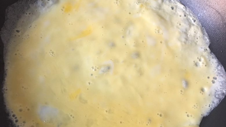 咖喱蛋包饭,7️⃣ 热锅冷油倒入鸡蛋液，快速转动锅使其均匀摊开。