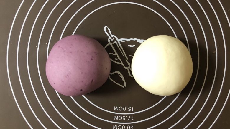 小清新紫薯馒头卷,把揉好的面团平均分成两份，一份揉进紫薯粉，紫薯粉比较干，可以滴一些水，湿润以后再揉，揉成颜色均匀的面团。