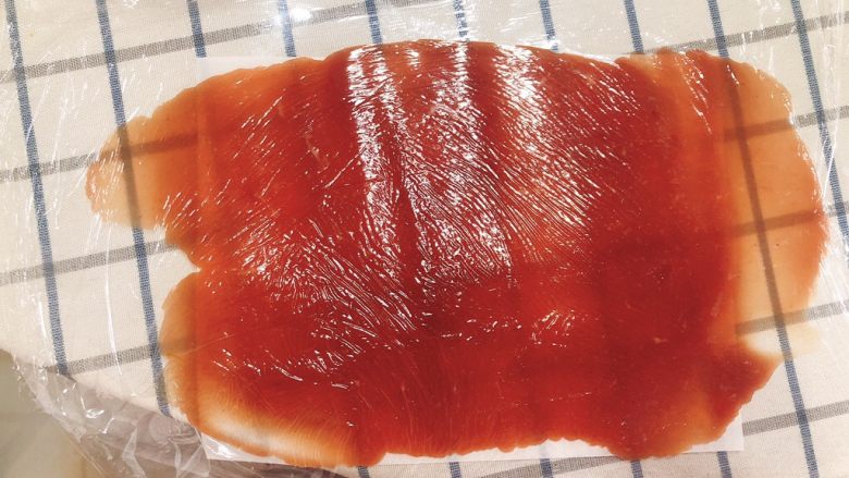 猪肉脯-零食、年货,表面铺上一层保鲜膜，用擀面仗擀成一块薄薄的肉片。