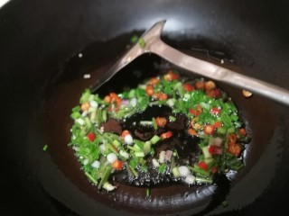 酱拌折耳根,锅中放适量油，油微热时倒入葱白、香菜茎和小米椒，改小火。
