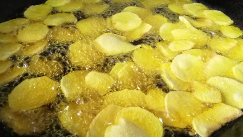 蚝油肉炒香菇土豆片,锅内倒油烧八分热，放入土豆片，炸至飘至油面变金黄色即可捞出。