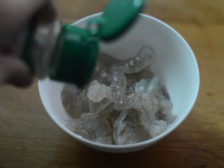 芦笋彩椒虾球,将处理好的虾放入碗中，调入少许胡椒粉和料酒，腌制一会