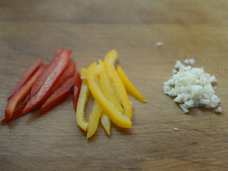 芦笋彩椒虾球,红、黄甜椒切丝，蒜切碎沫