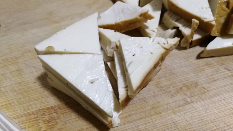 素鸡豆腐炒青椒,切好片后再切成正方形，分别对角再切两刀，切出四个三角形。