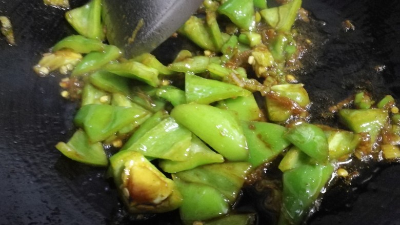素鸡豆腐炒青椒,继续煸炒至小青椒微熟，入酱油味。
