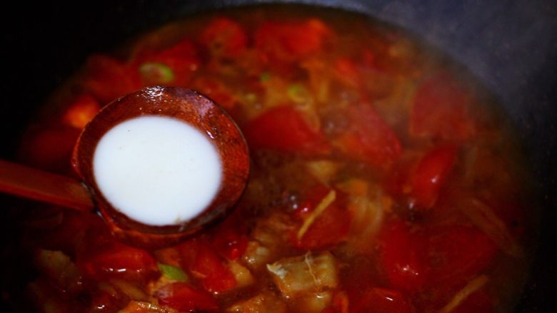 鳕鱼番茄羹,把搅拌均匀的淀粉倒入锅中勾芡。