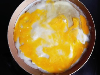 宝宝辅食—肉松香肠煎饼果子,煎至面糊半凝固的时候，打上一个鸡蛋用铲子摊匀