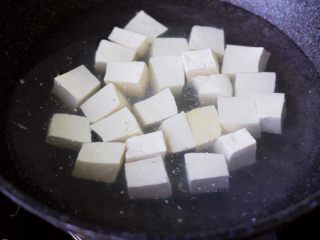 海带豆腐炖梭子蟹,北豆腐用刀切成小块，锅中倒入适量清水煮沸后，加入一勺盐后，放入北豆腐进行焯水。
