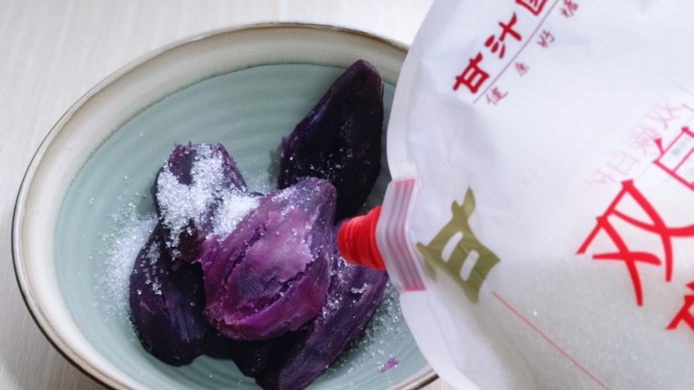 补血养颜～低脂紫薯红糖糯米饼,将蒸熟的紫薯放入器具中，加入白砂糖！
