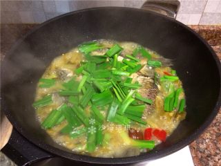 酸菜烧鲫鱼,放入蒜苗叶煮2分钟。