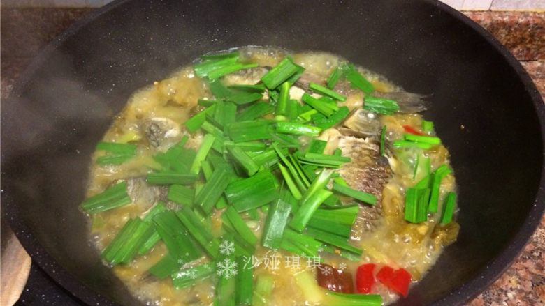 酸菜烧鲫鱼,放入蒜苗叶煮2分钟。