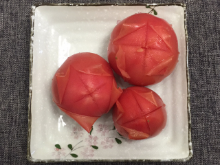 番茄土豆炖牛腩,先将3个番茄顶部划十字刀，放入碗中，用沸水烫30秒，撕掉外皮（烫过后的番茄皮特别好撕），切成小块
