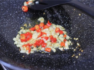 鸡胗拌黄瓜,锅里放入少量食用油，油烧热后，下入蒜末和小米椒圈，炒出香味。