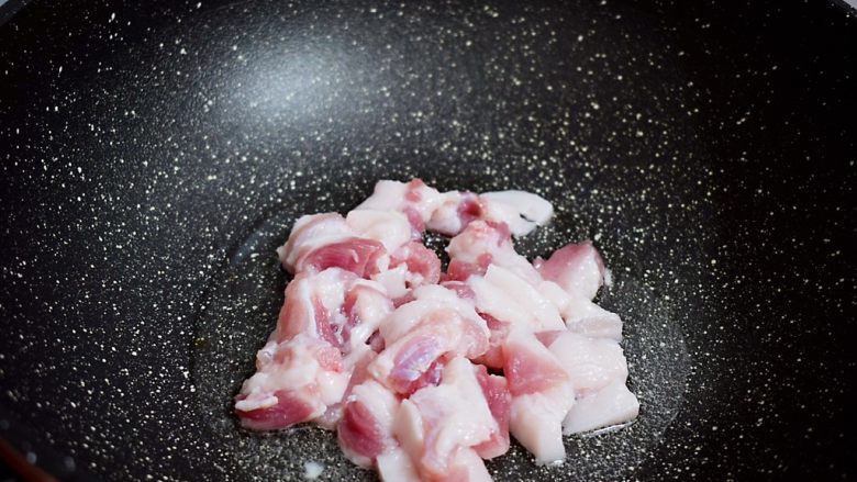干煸菜花,锅中倒入适量的食用油烧热，放入猪肉翻炒至变色变白