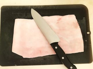 自制猪皮冻,用刀刮去猪皮表面的猪毛