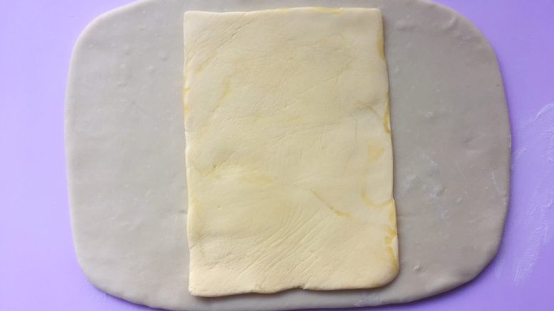 可颂热狗,冰箱取出冷冻的黄油片，用剪刀裁开保鲜袋，将黄油片放在面片中间 