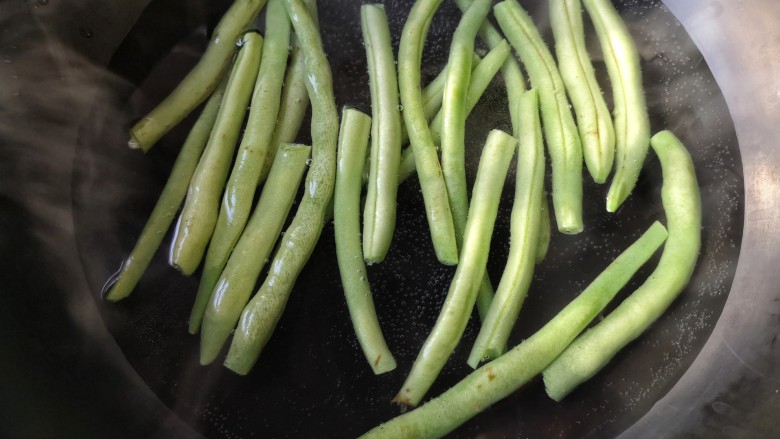干煸芸豆,将摘好的芸豆去开水焯2-3分钟，待芸豆变色。（芸豆加热不够会导致中毒）