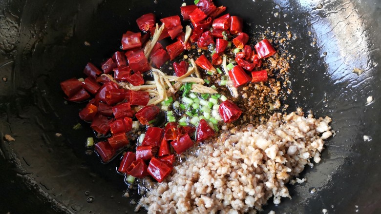 干煸芸豆,把炒好的肉末置于锅内一边，在锅底油处下入葱姜和干辣椒麻椒爆香。