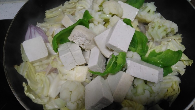 洋白菜乱炖,倒入菜花、淀粉、菜椒，盖盖中火炖2分钟。