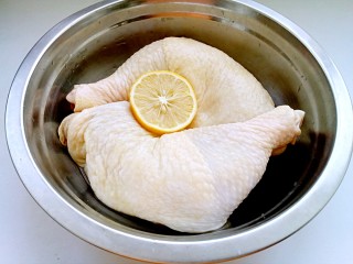 口水鸡,将鸡腿用热水洗净，除去表皮的油脂。然后用柠檬汁将鸡腿抹匀，略微腌制一下，以除去腥味。