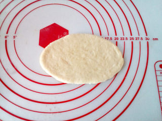 台式葱面包,取一个松弛好的面团，擀成椭圆形。