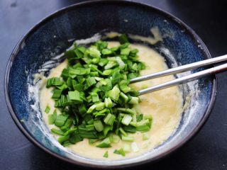 鳕鱼韭菜鸡蛋饼,这个时候加入用刀切碎的韭菜末，记住韭菜不要切的太碎，以免影响口感。