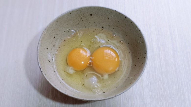 营养早餐 海参蒸蛋羹,将鸡蛋敲入碗中。
