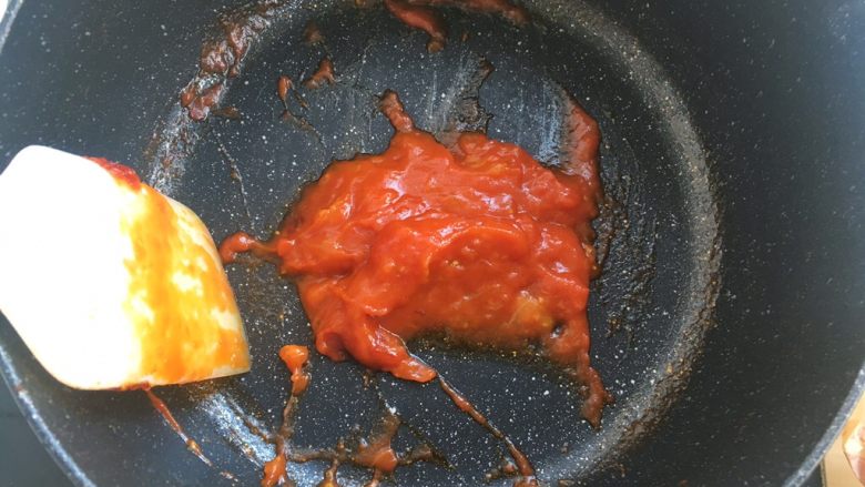 黑椒牛肉肠披萨,加入番茄酱，一起翻炒至西红柿融化，变成泥状后关火，用刮刀碾压去掉西红柿皮