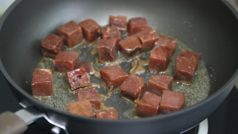 秋葵黑椒牛肉,锅里倒入少许油，烧热后下牛肉粒翻炒煎制
