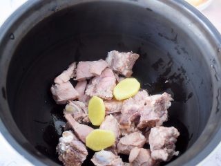 猪骨莲藕玉米胡萝卜汤,把猪骨、姜片放入高压锅内胆中