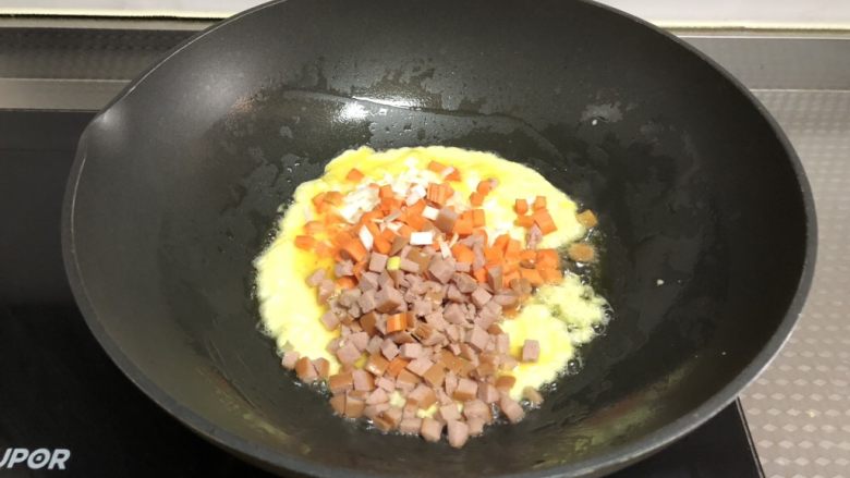 黑椒火腿炒饭,鸡蛋半凝固时放入胡萝卜，火腿和葱花