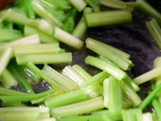 学做家常菜——芹菜百合炒腰果,起油锅，倒入芹菜炒匀