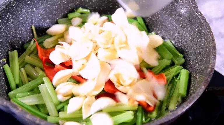 学做家常菜——芹菜百合炒腰果,加入盐、糖，炒匀