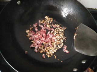 腊味糯米卷,锅内放油加热放入冬菇和切碎的腊肠放入适量的盐抄熟。