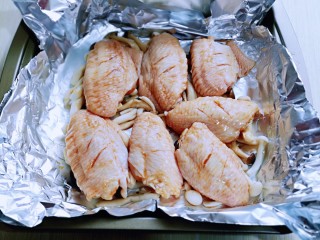什锦烤鸡翅,把腌制好的鸡翅摆放在菌菇上。