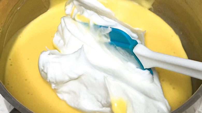 蓝莓蛋糕卷,取三分之一的蛋白霜进入蛋黄糊中。