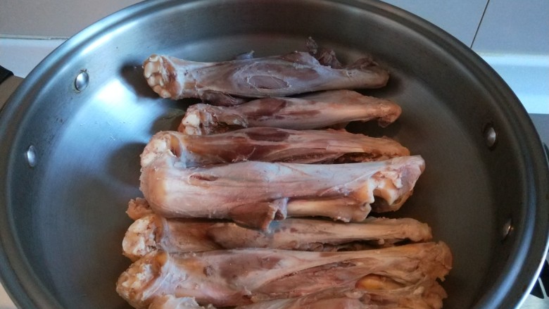 新文美食  红焖羊骨汤,把洗干净的羊腿骨码放皇后锅中。
