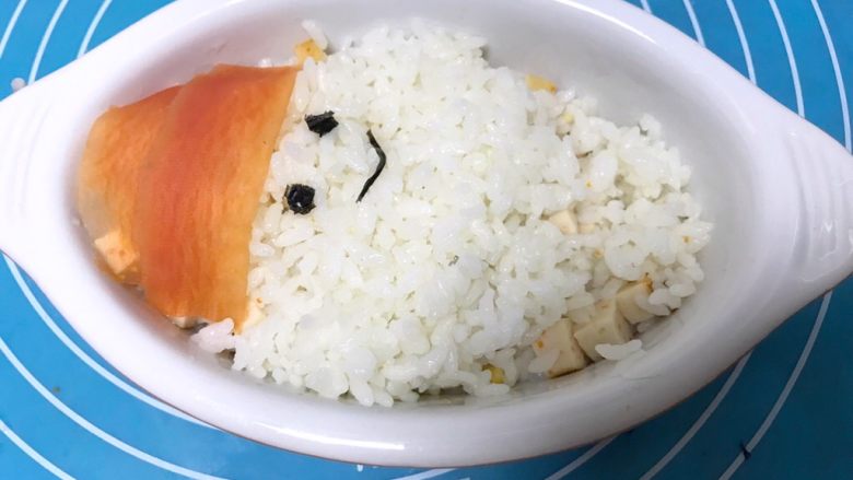 儿童雪人便当,继续加入些白米饭，用<a style='color:red;display:inline-block;' href='/shicai/ 279'>海苔</a>装饰雪人眼睛和嘴巴。