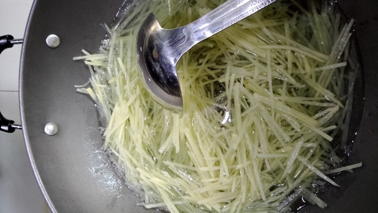 酸辣土豆丝,水烧开放入土豆丝焯水。焯好过后把土豆丝倒入过滤网，用凉水冲凉。