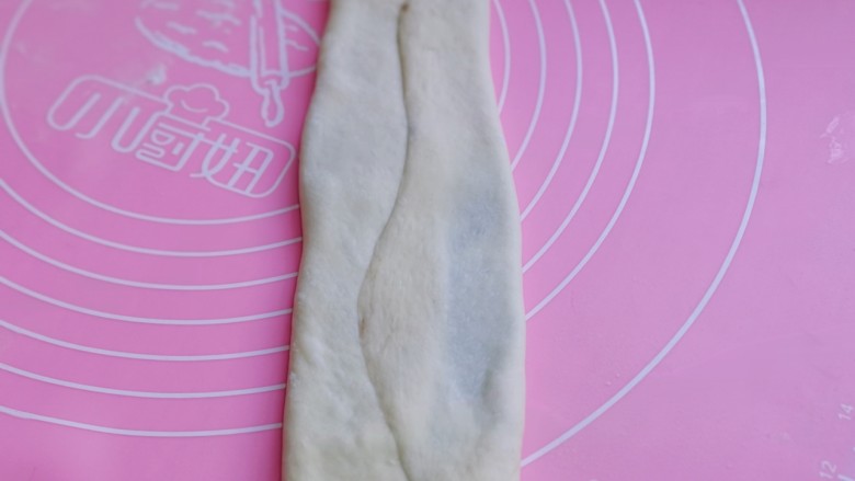 中种豆沙吐司面包,将擀好的长舌状两边向中间对折，用擀面杖轻轻擀长。