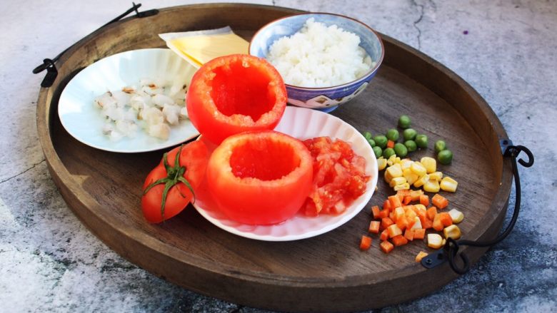 芝士焗番茄鲜虾米饭盅,用小勺将番茄肉挖出来，番茄盅留做当餐具，番茄肉用于炒饭。
