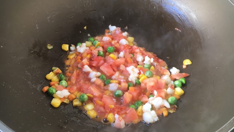 芝士焗番茄鲜虾米饭盅,放入番茄粒翻炒均匀。